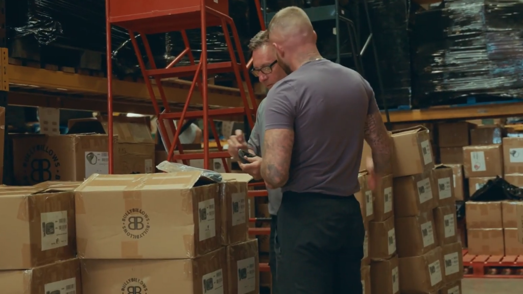 An image showing two warehouse workers check an order item.