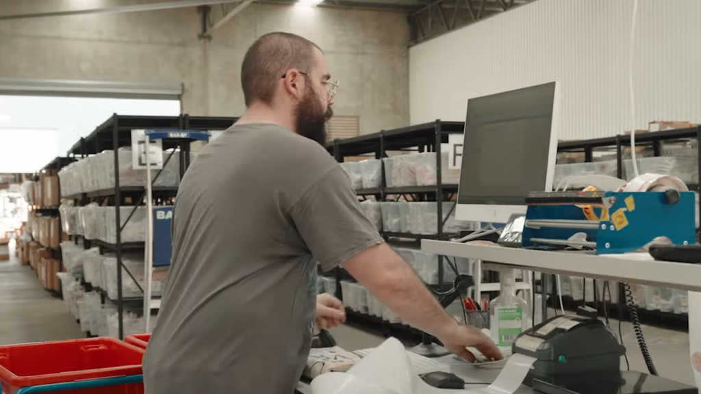 An image of a warehouse worker using the Peoplevox platform in a warehouse.