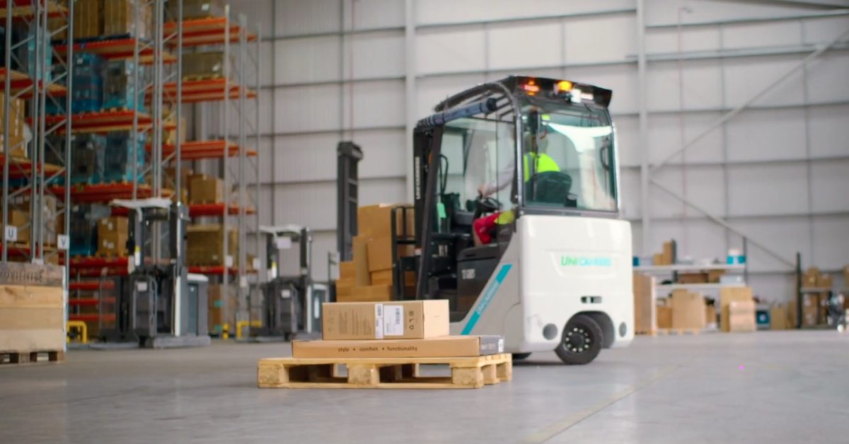 An image from a warehouse showing a pallet with two orders stacked on top of each other. Behind the pallet is a forklift.