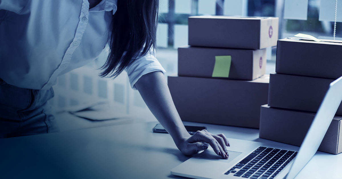 An image showing someone working in a warehouse. To her side are several packaged orders ready to be shipped.